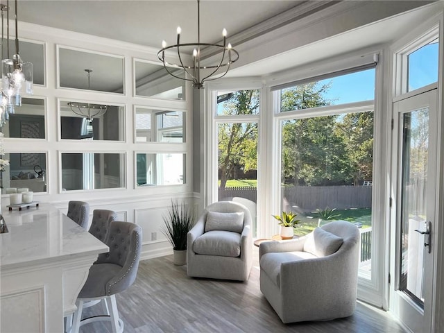 sunroom / solarium featuring a notable chandelier