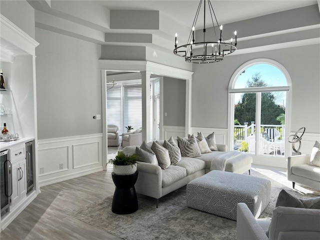 living room featuring wine cooler, hardwood / wood-style floors, and a high ceiling