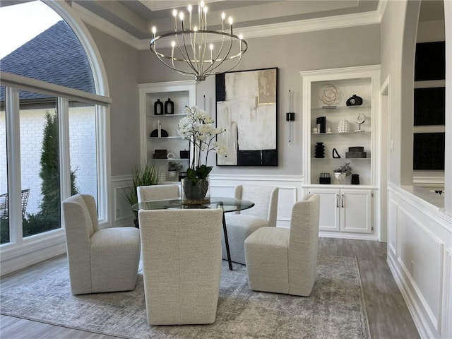 dining area featuring built in features, hardwood / wood-style floors, plenty of natural light, and ornamental molding