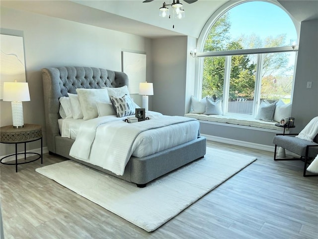 bedroom with wood-type flooring, multiple windows, and ceiling fan