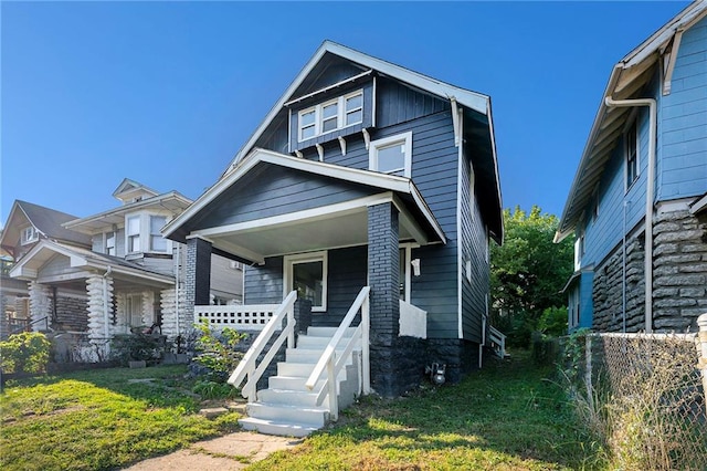 view of front of house with covered porch and a front yard