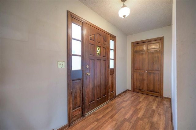 entryway with hardwood / wood-style floors and a textured ceiling