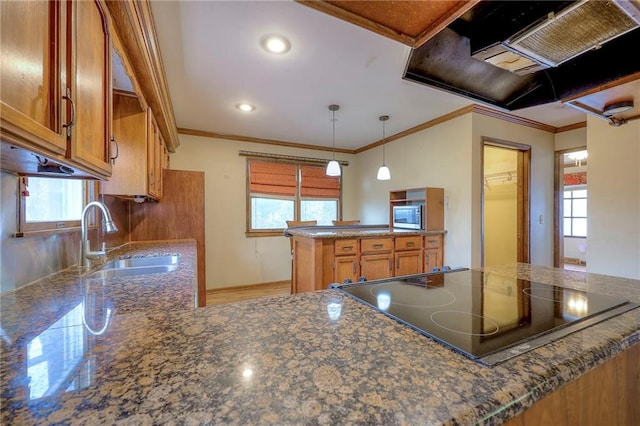 kitchen featuring kitchen peninsula, crown molding, sink, and decorative light fixtures