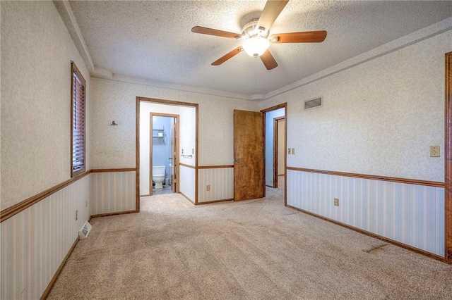 carpeted spare room with a textured ceiling and ceiling fan