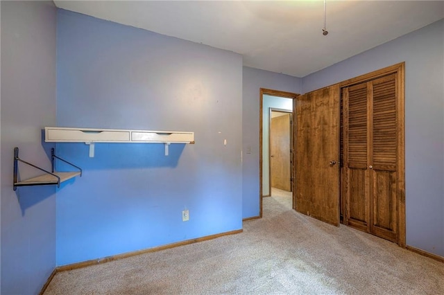 unfurnished bedroom with light colored carpet and a closet