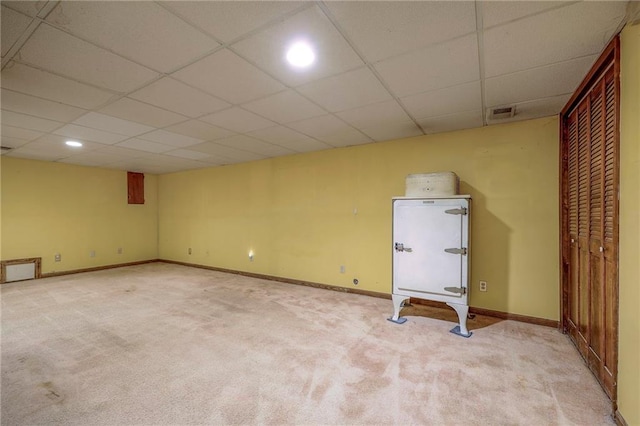 basement with light colored carpet and a drop ceiling