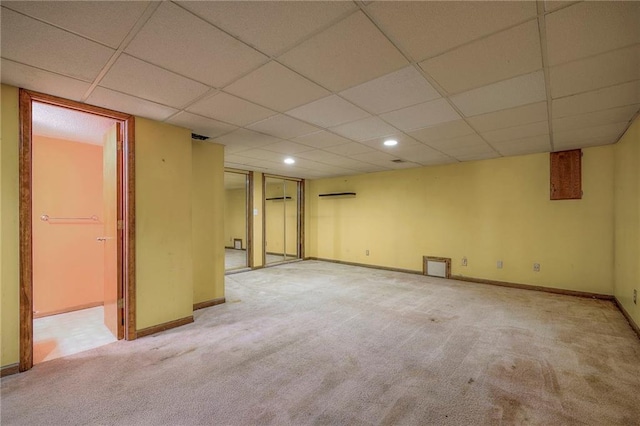 basement featuring light colored carpet and a drop ceiling