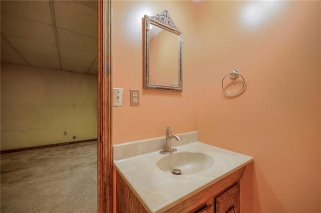 bathroom with a paneled ceiling and vanity