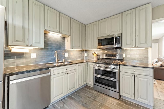 kitchen featuring hardwood / wood-style floors, decorative backsplash, sink, and appliances with stainless steel finishes