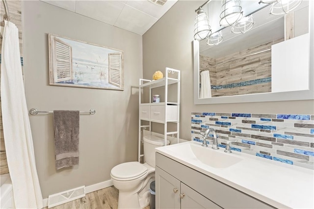 full bathroom featuring tasteful backsplash, hardwood / wood-style floors, toilet, shower / tub combo with curtain, and vanity