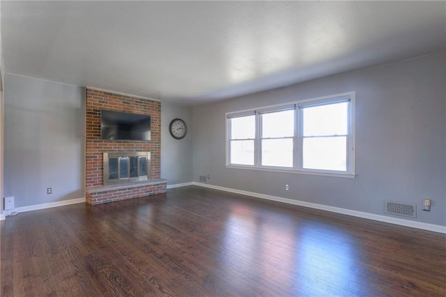 unfurnished living room with dark hardwood / wood-style flooring and a fireplace