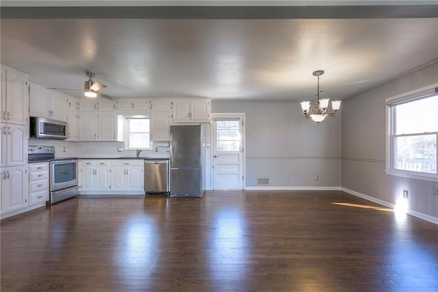 kitchen with appliances with stainless steel finishes, dark hardwood / wood-style flooring, tasteful backsplash, white cabinets, and hanging light fixtures