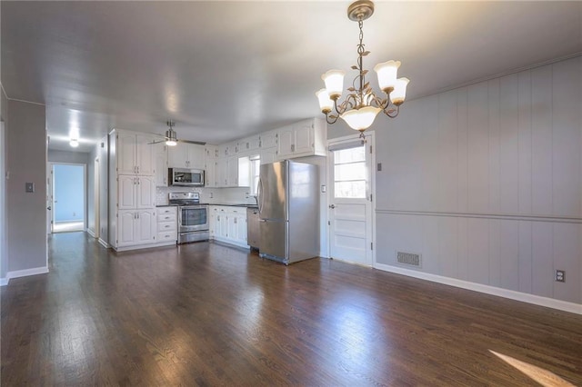 kitchen featuring hanging light fixtures, dark hardwood / wood-style floors, white cabinets, ceiling fan with notable chandelier, and appliances with stainless steel finishes