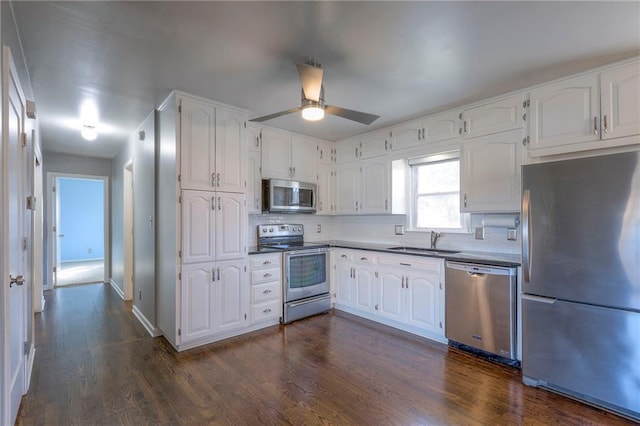 kitchen featuring ceiling fan, sink, dark hardwood / wood-style floors, white cabinets, and appliances with stainless steel finishes