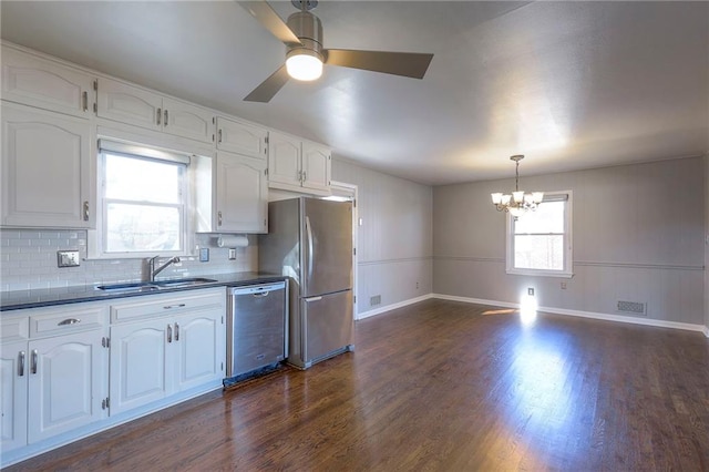 kitchen with decorative backsplash, white cabinets, dark hardwood / wood-style floors, and appliances with stainless steel finishes