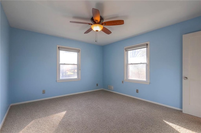 carpeted spare room featuring ceiling fan