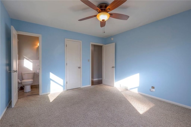 unfurnished bedroom featuring ceiling fan, ensuite bathroom, and light carpet