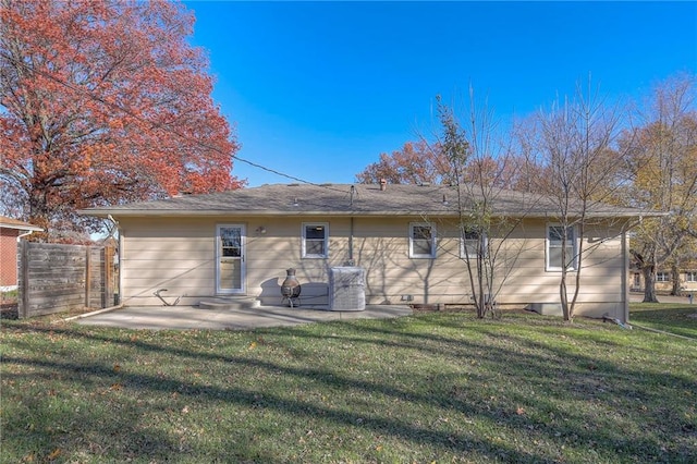 rear view of house with a lawn and a patio