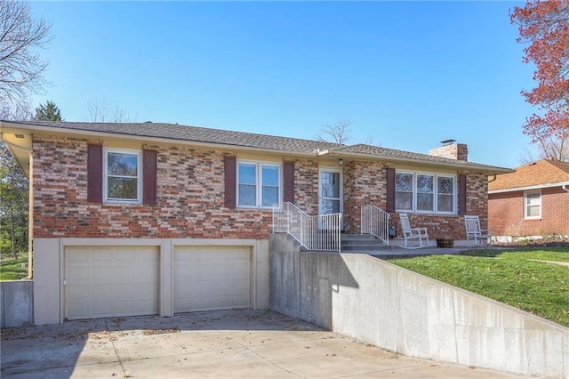 view of front facade with a front lawn, concrete driveway, an attached garage, brick siding, and a chimney