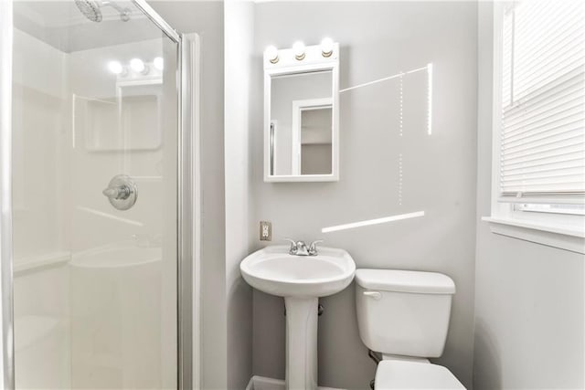 bathroom with a shower with shower door and toilet