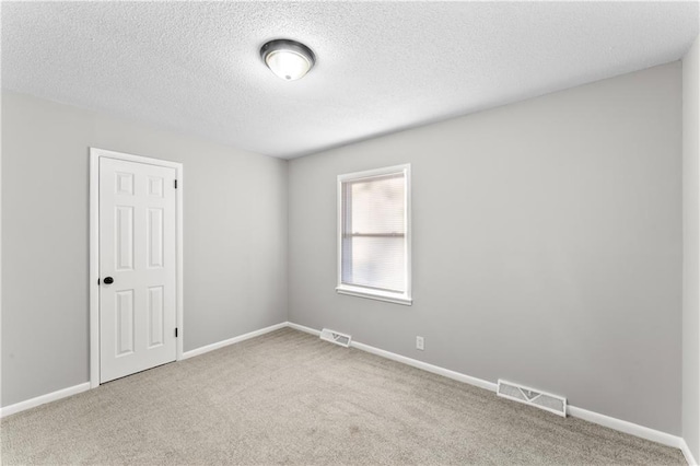 carpeted spare room with a textured ceiling