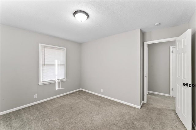 carpeted spare room with a textured ceiling