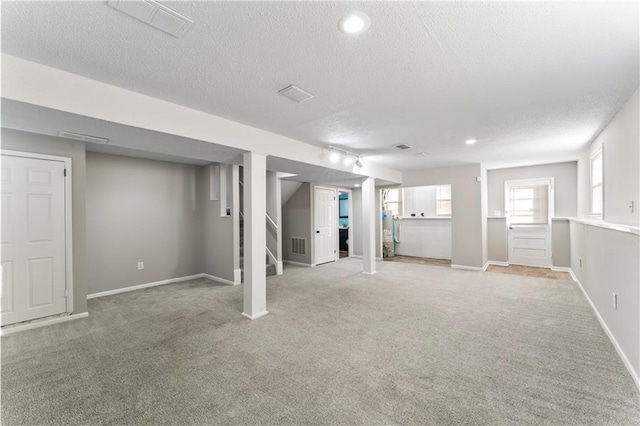 basement with light colored carpet and a textured ceiling