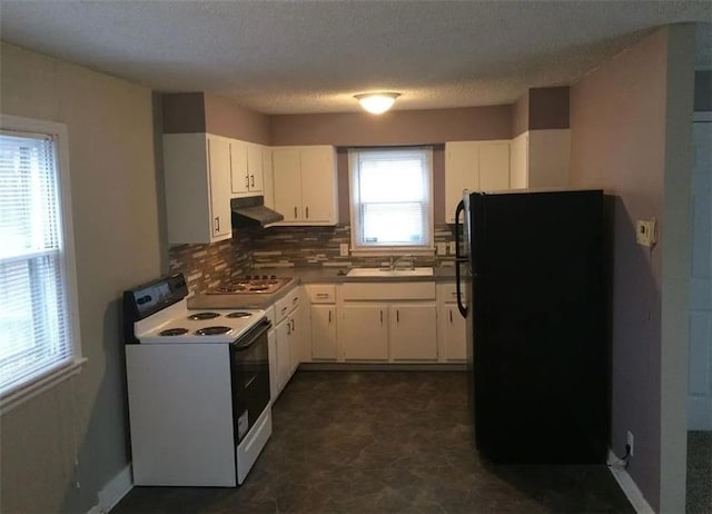 kitchen featuring electric stove, white cabinetry, black refrigerator, and plenty of natural light