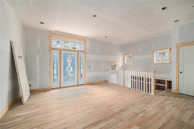 spare room with a textured ceiling and light wood-type flooring