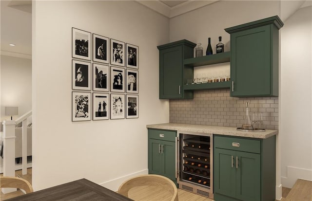 bar with green cabinetry, backsplash, beverage cooler, and light hardwood / wood-style flooring