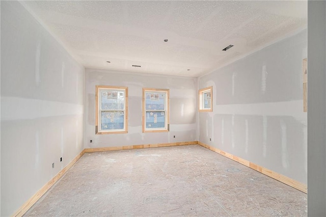 unfurnished room with a textured ceiling