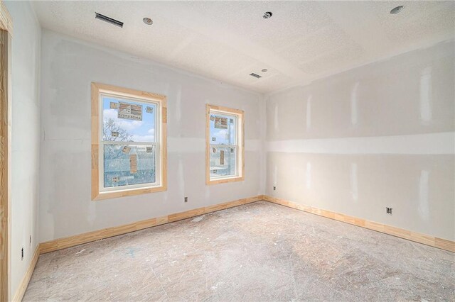 empty room featuring lofted ceiling and a textured ceiling