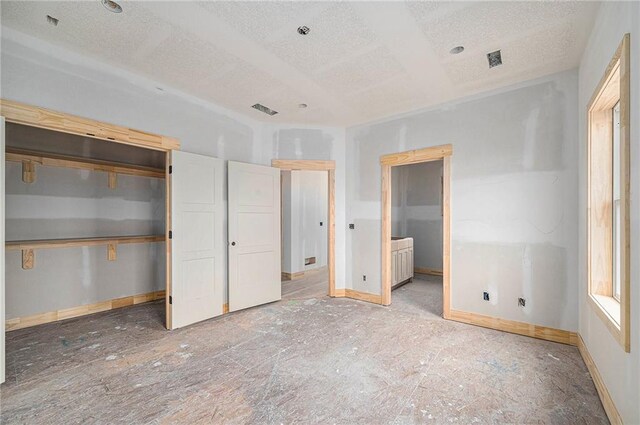 unfurnished bedroom with a textured ceiling and ensuite bathroom