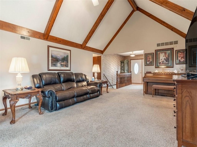 carpeted living room with beam ceiling and high vaulted ceiling