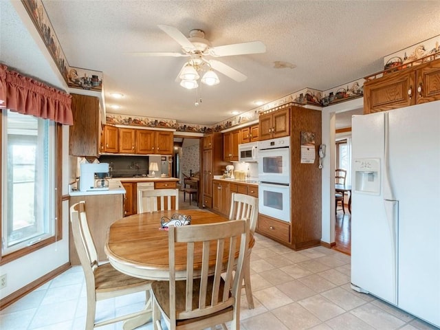 tiled dining area featuring ceiling fan and a textured ceiling