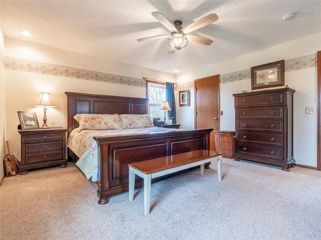 carpeted bedroom featuring a textured ceiling and ceiling fan