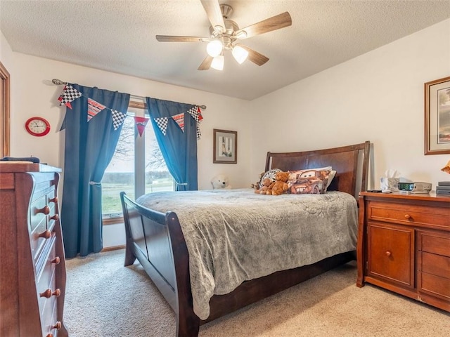 carpeted bedroom with ceiling fan and a textured ceiling