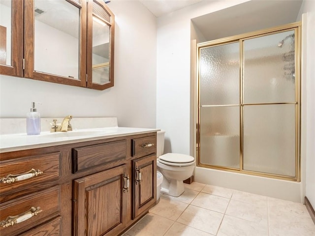 bathroom featuring tile patterned flooring, vanity, a shower with door, and toilet