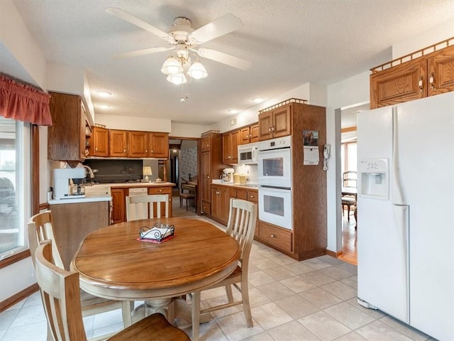 kitchen featuring ceiling fan, light tile patterned flooring, a textured ceiling, and white appliances