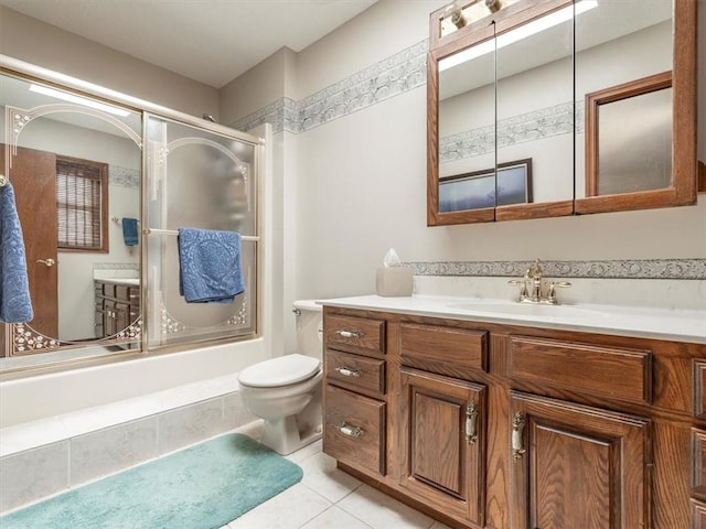 full bathroom with bath / shower combo with glass door, vanity, toilet, and tile patterned flooring