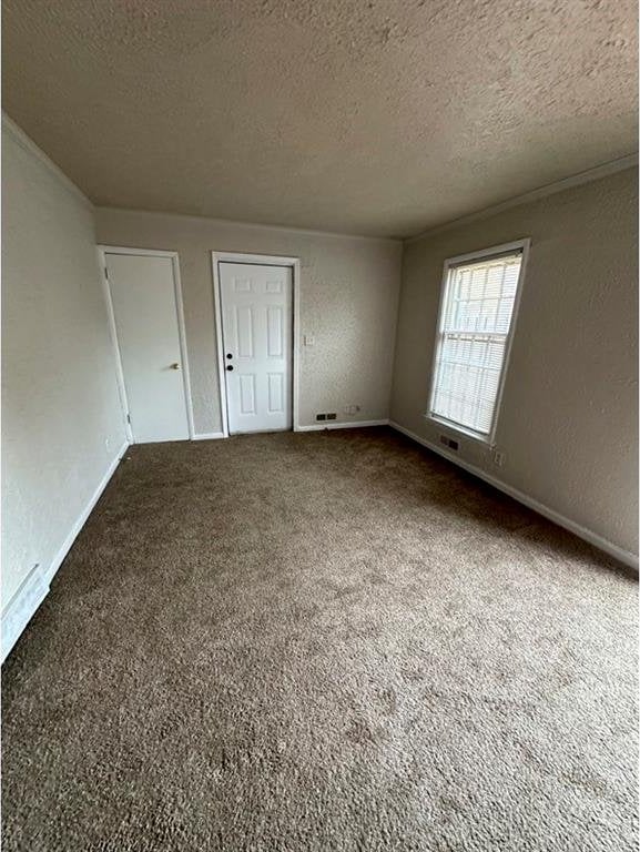 unfurnished bedroom featuring carpet floors and a textured ceiling