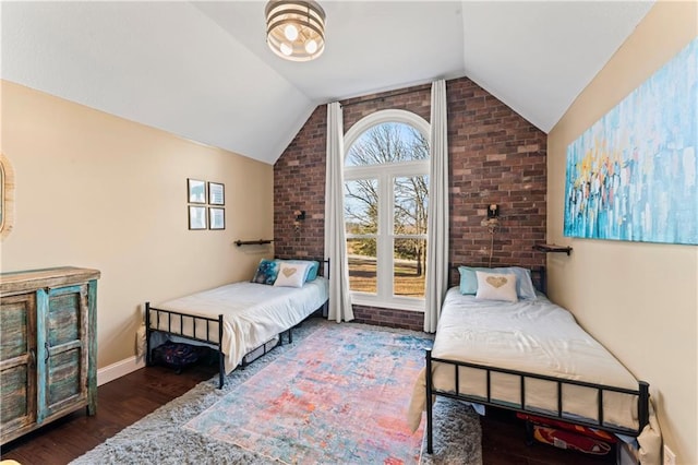 bedroom with dark hardwood / wood-style flooring, lofted ceiling, and brick wall