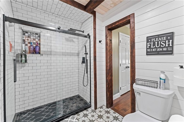 bathroom with beamed ceiling, hardwood / wood-style flooring, a shower with door, and wood walls