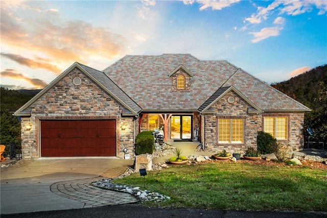 view of front of home featuring driveway, a garage, and a yard