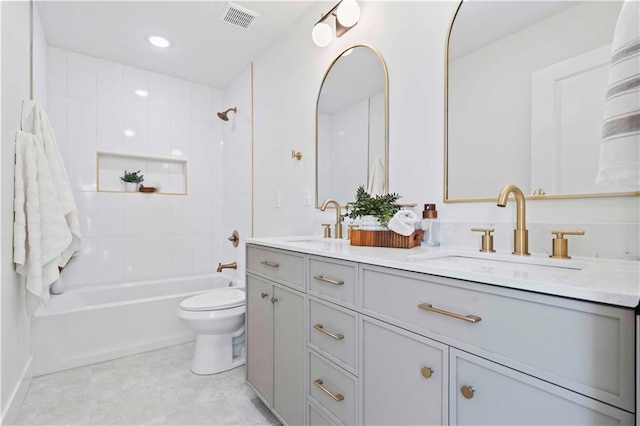 bathroom with a sink, visible vents, toilet, and double vanity