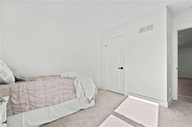 carpeted bedroom featuring baseboards and visible vents