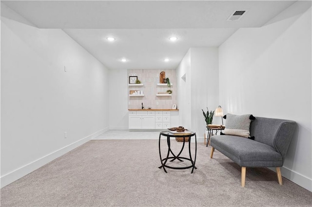 sitting room featuring visible vents, light carpet, recessed lighting, indoor wet bar, and baseboards