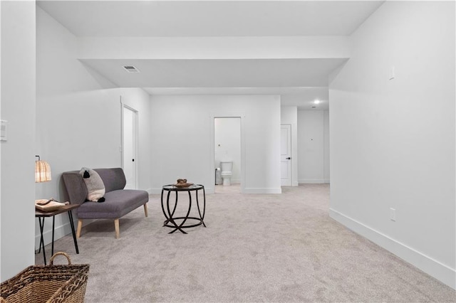 living area featuring visible vents, baseboards, and light colored carpet