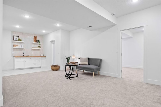 sitting room with light carpet, visible vents, recessed lighting, and baseboards