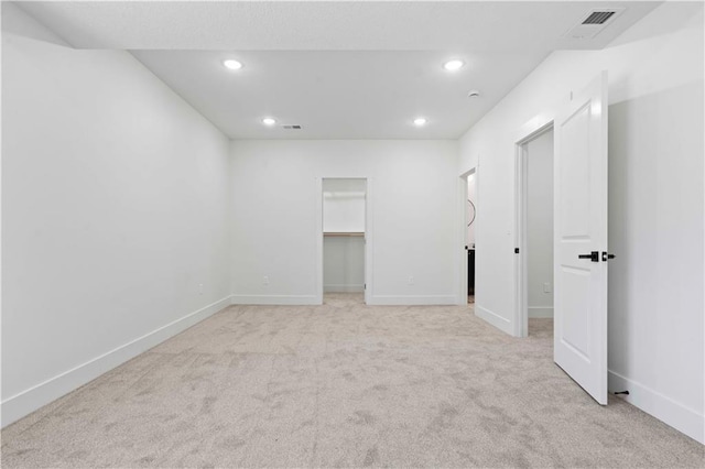 spare room with recessed lighting, light colored carpet, and baseboards